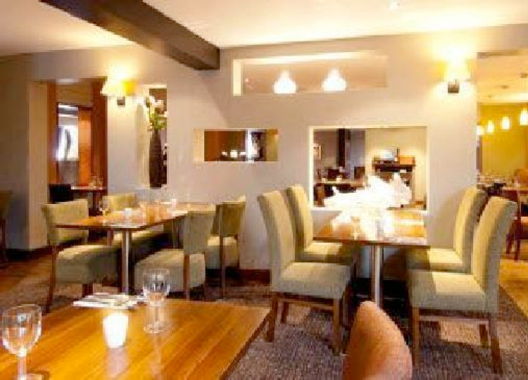 The hotel restaurant, with wooden tables and upholstered chairs
